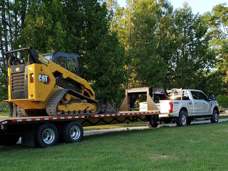 Parm Construction truck towing heavy equipment on a float trailer 